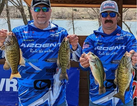 Two mens holding two fishes each