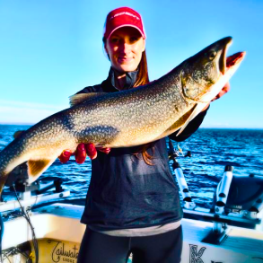 a person on a boat and holding a fish with their hands 