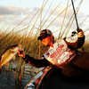 a person on a boat and holding a fish with a hand