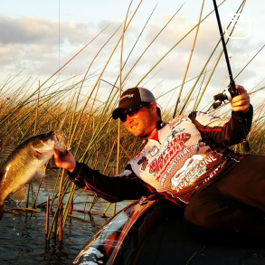 a person on a boat and holding a fish with a hand